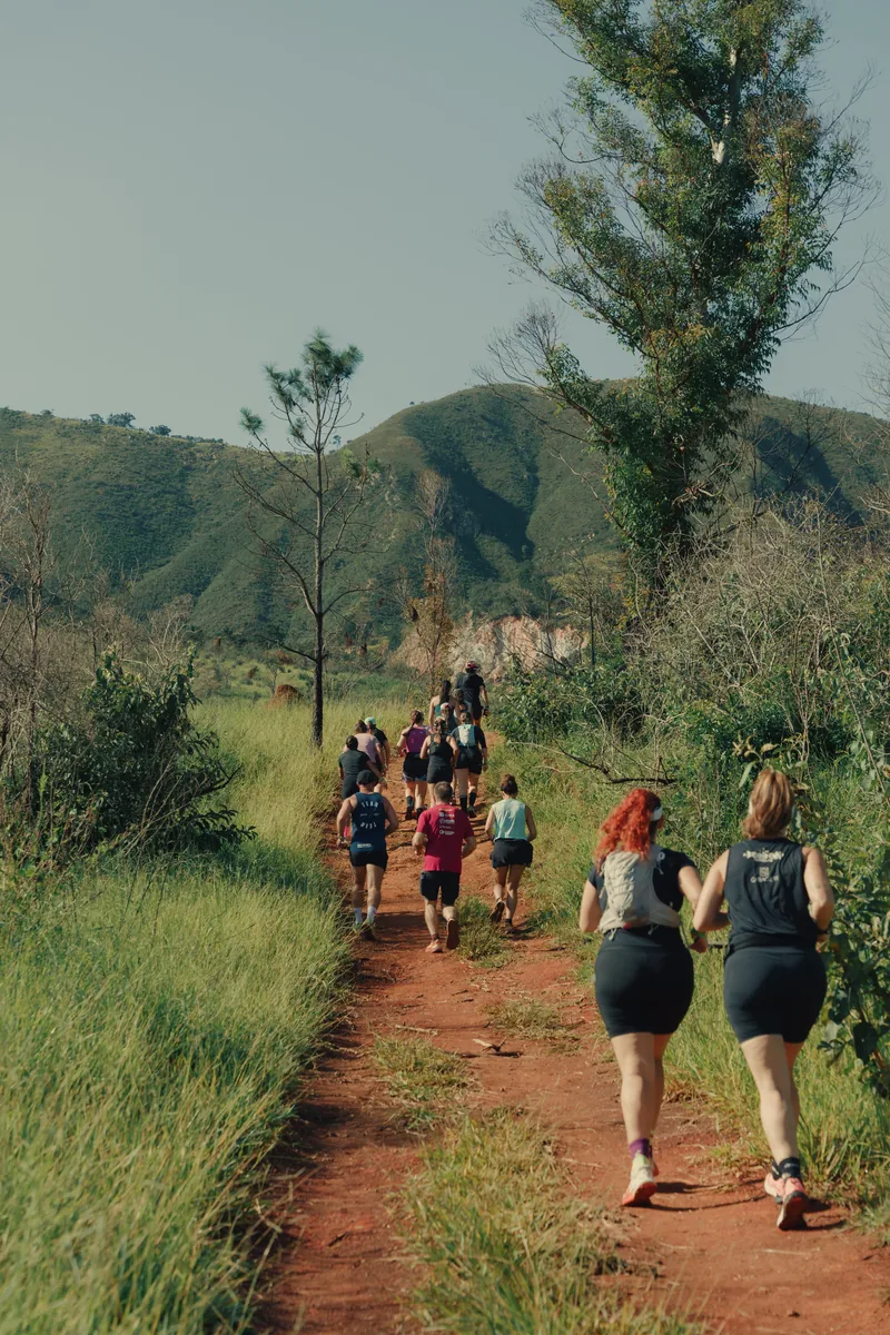 Grupo subindo a trilha de terra vermelha da serra